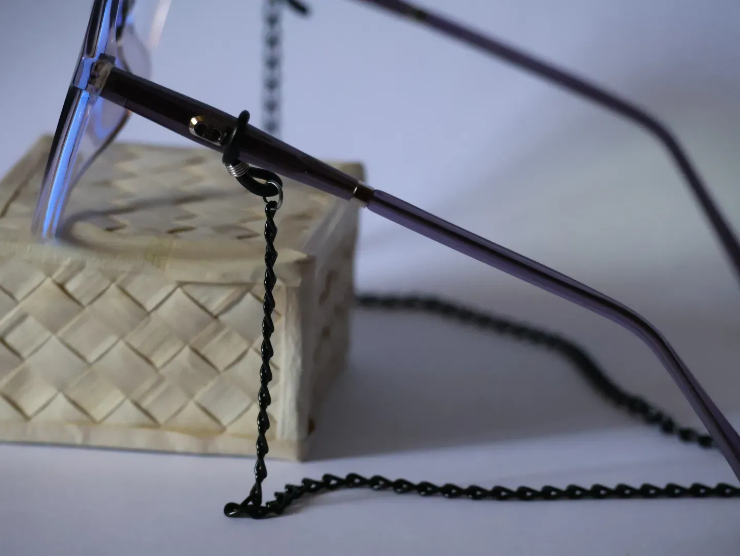 Elegant metal eyeglass chain attached to a pair of reading glasses.