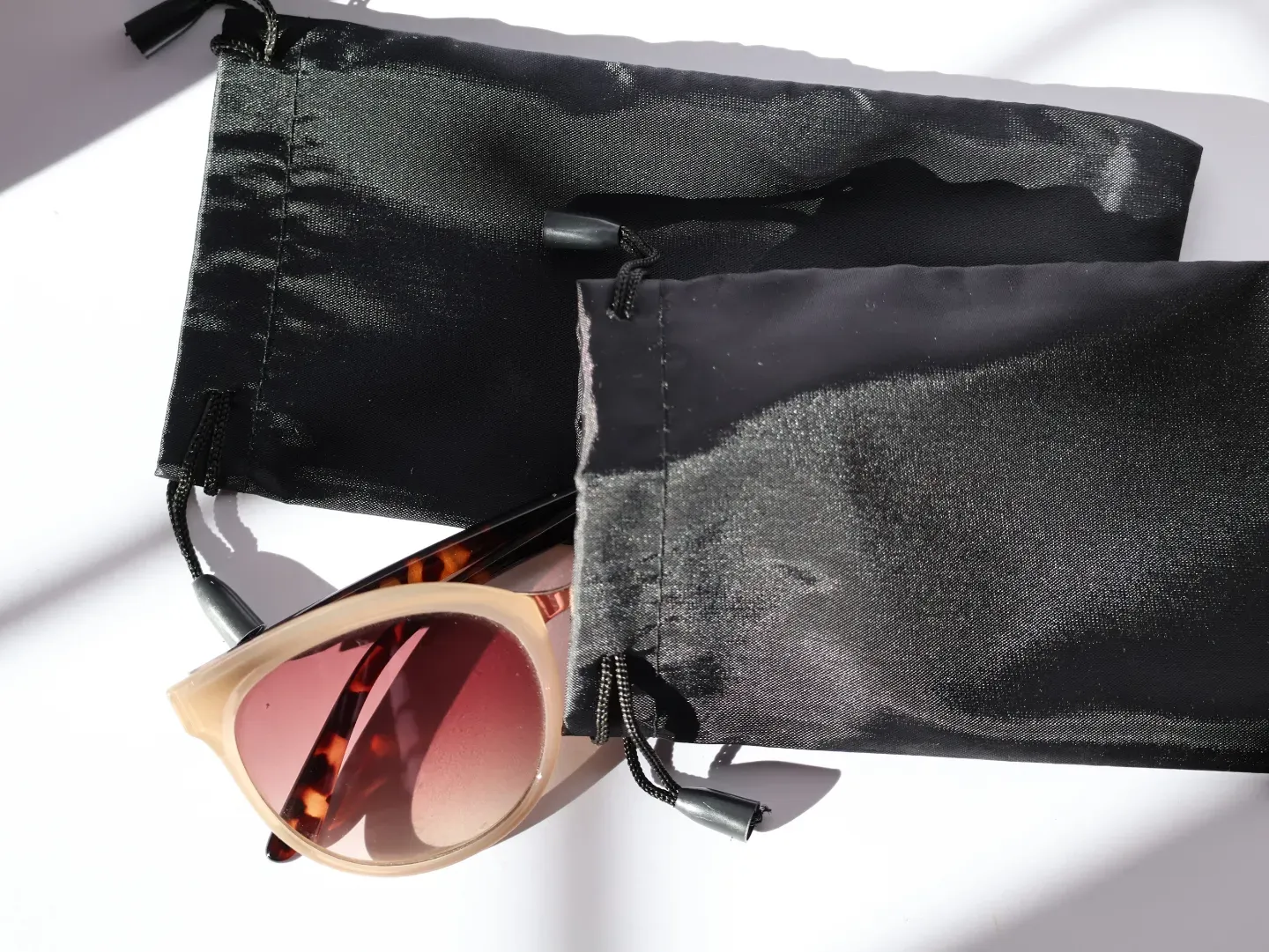 Soft microfiber drawstring pouch protecting a pair of sunglasses.
