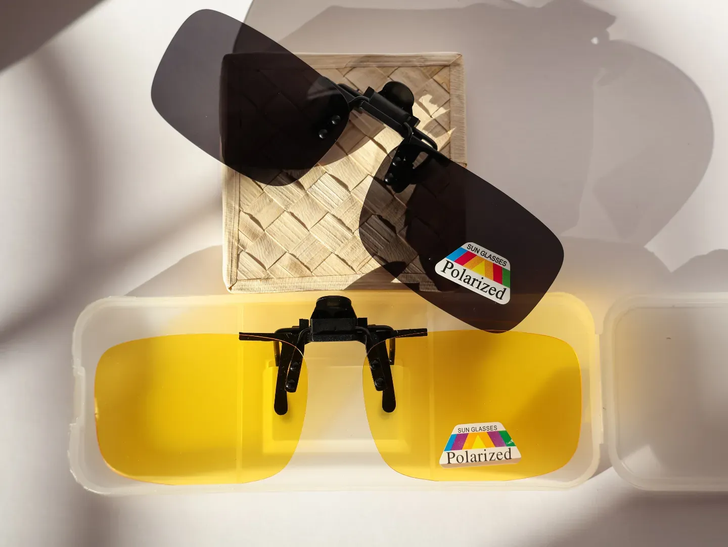 Dark grey polarized clip-on lenses attached to prescription spectacles.