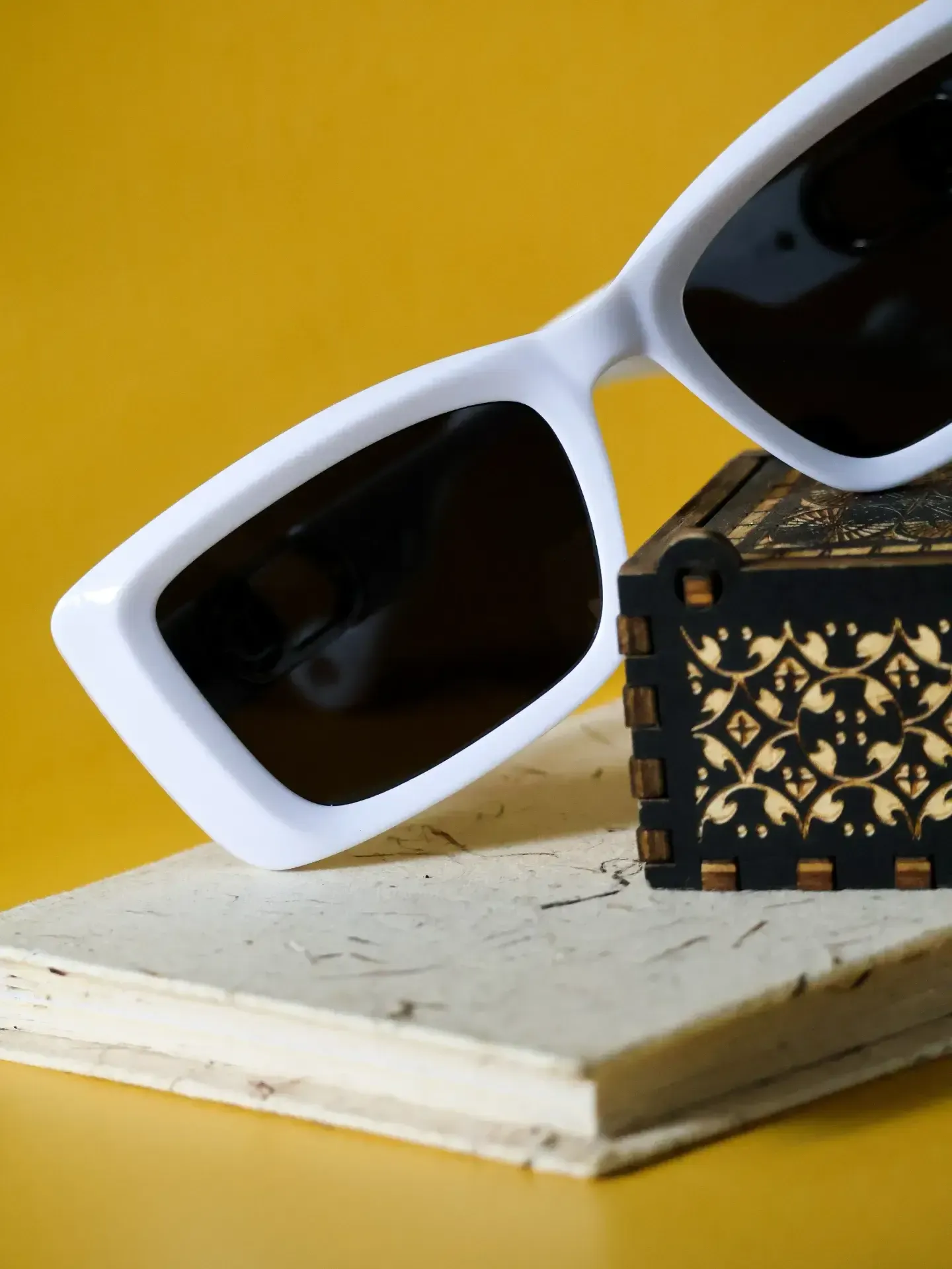 Side angle of white rectangular sunnies. High-contrast glasses frames with dark UV-blocking lenses.